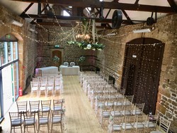 Elevated view of a hall in a barn set out for seating for a wedding. Wedding venues in Northampton.