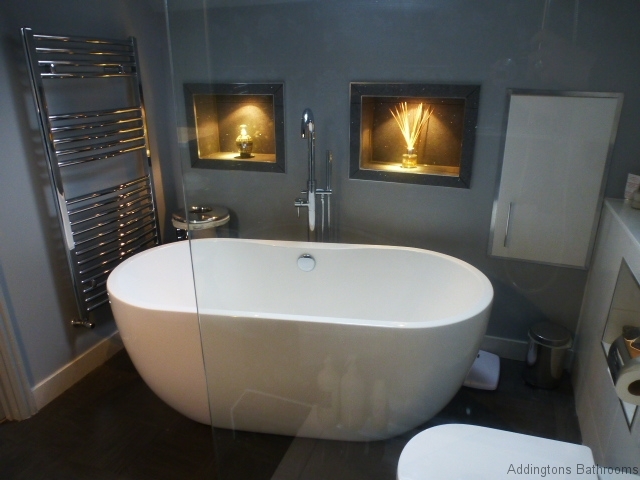 a freestanding white bath with a chrome towell radiator