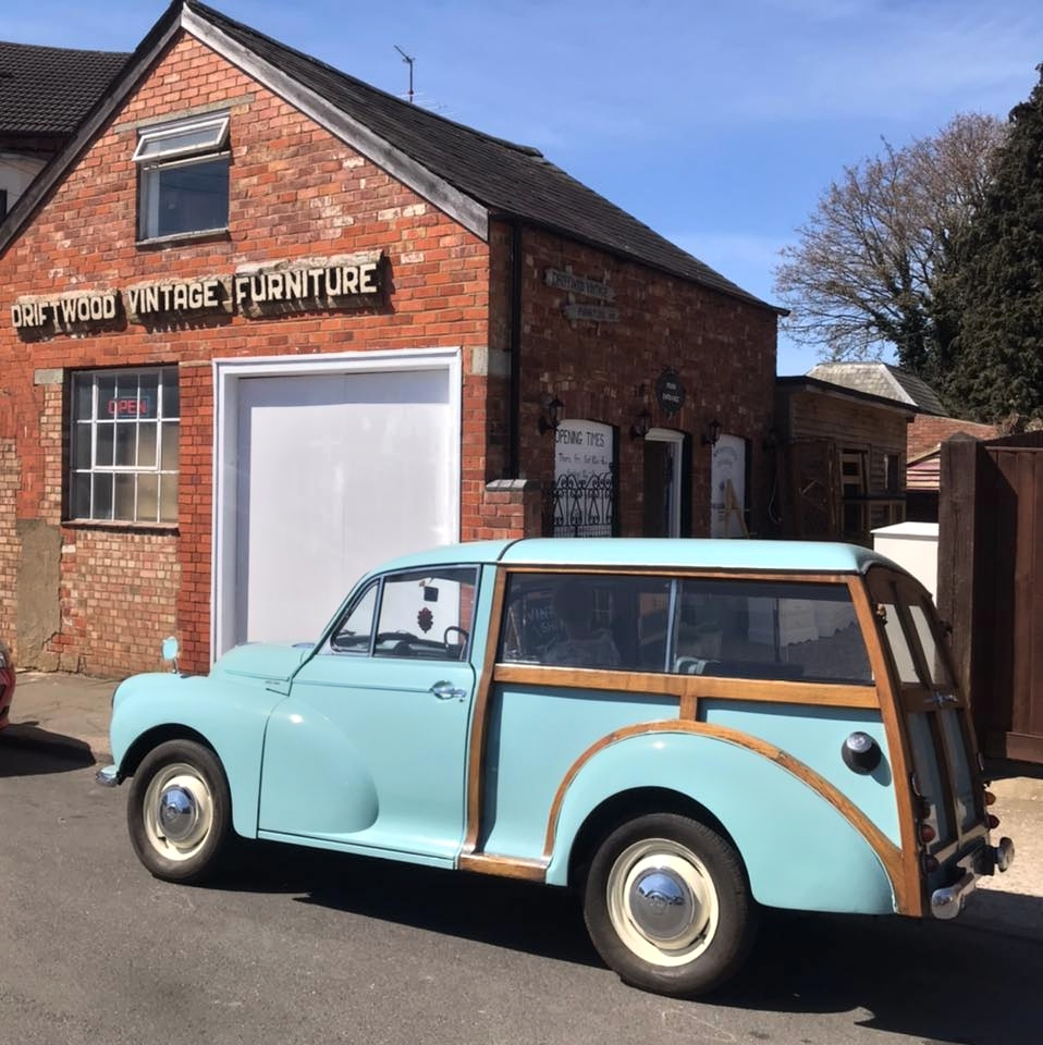 a blue morris minor in front of a vintage furrniture shop.  Furniture in Northampton.