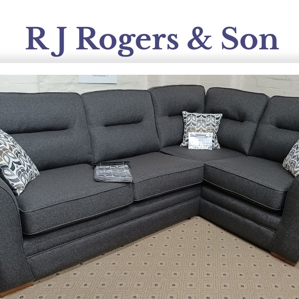 a charcoal coloured L shaped corner settee with lighter grey patterned cushions on a spotted carpet