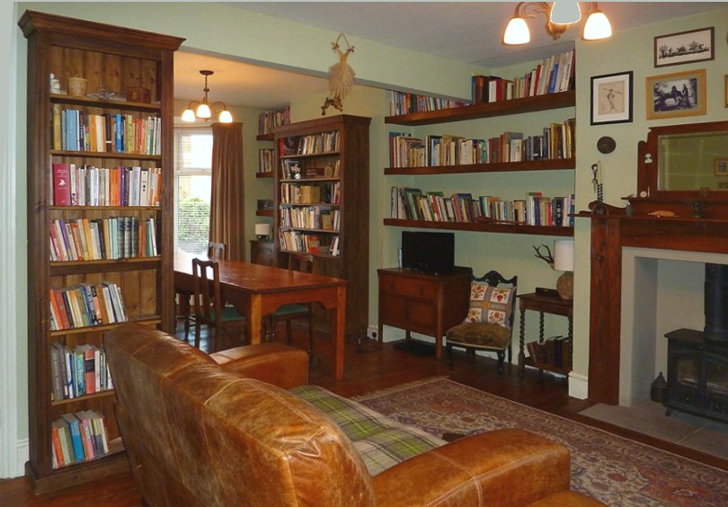 a living room with built in bookcases and shelves.